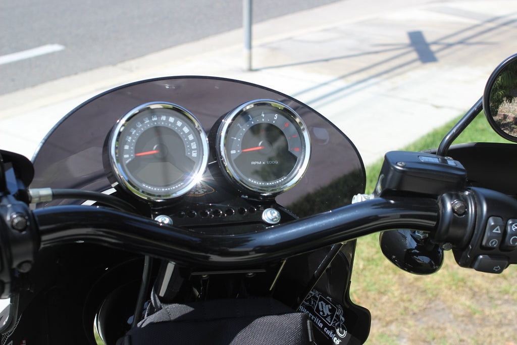 Dual gauge relocation kit mounted on Harley Dyna T-bars with speedometer and tachometer