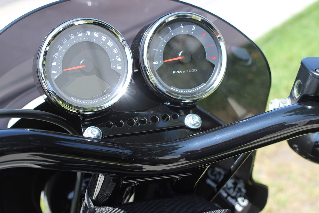 Dual gauge relocation kit mounted on Harley Dyna T-bars with speedometer and tachometer