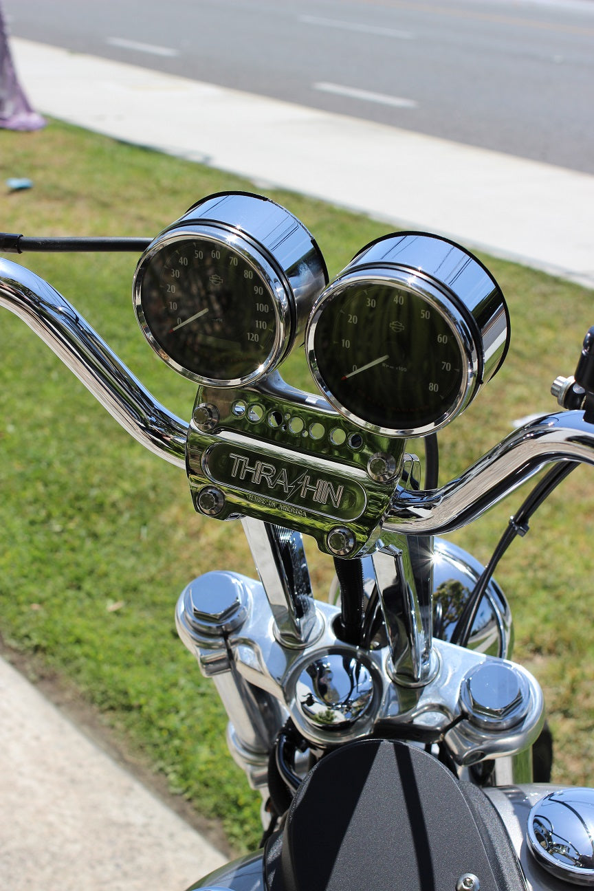 Dual gauge relocation kit mounted on Harley Dyna T-bars with speedometer and tachometer